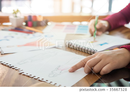 Close up of professional Fashion designer working and drawing sk 35667328