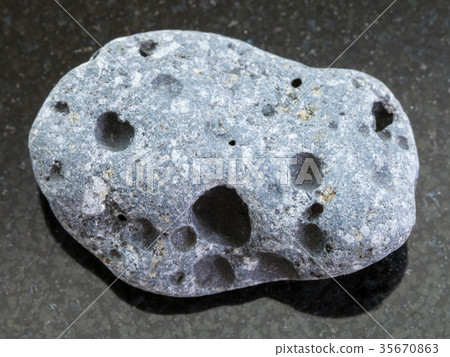 pebble of gray pumice stone on dark background 35670863