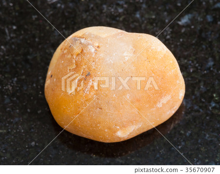 tumbled yellow chalcedony stone on dark 35670907