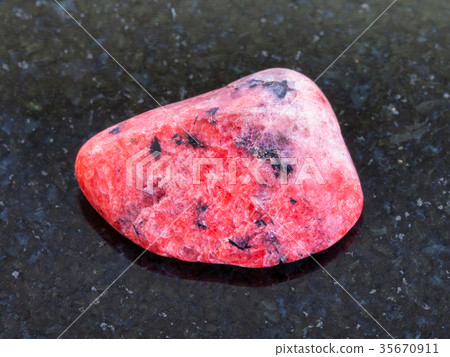 polished red Agate gemstone on dark background 35670911