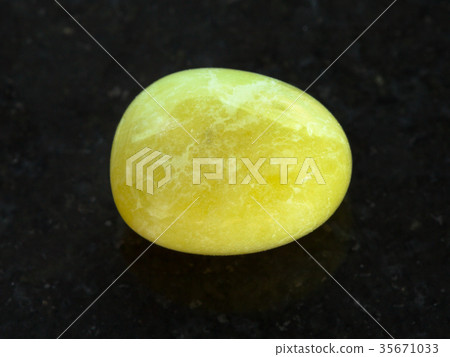 tumbled yellow calcite gemstone on dark 35671033