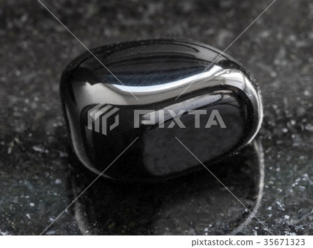 polished black Onyx gemstone on dark 35671323