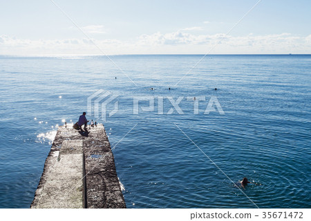 fisherman on pier and swimming people in Black Sea 35671472