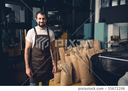 Smile coffee roaster worker standing near bags 35672206