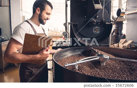 Happy coffee roaster controlling preparing beans 35672606