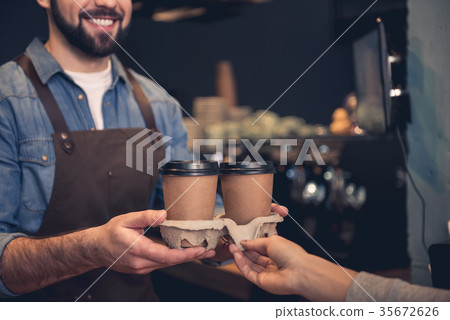 Cheerful barista giving mug of beverage 35672626