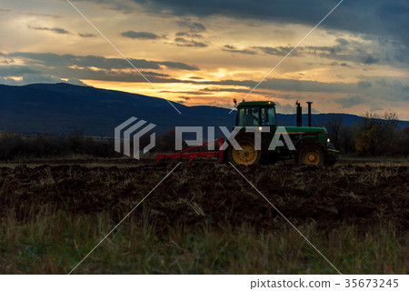 Tractor on the field by sunset. 35673245