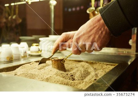 Close up hands of a man cooking turkish coffee on 35673274