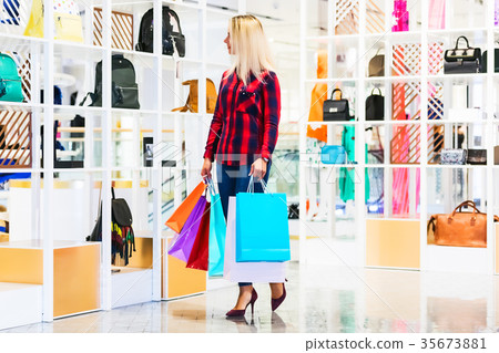 Young woman with shopping bags in the fashion store Young woman with shopping bags in the fashion store 35673881