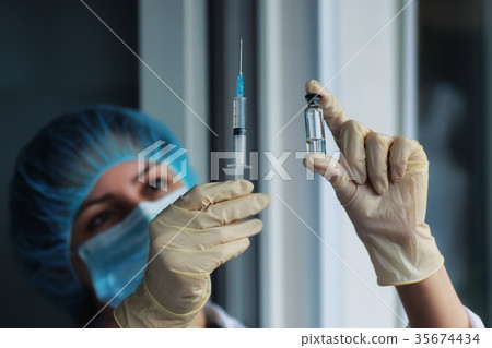 nurse hands holding syringe and ampoule nurse hands holding syringe and ampoule 35674434