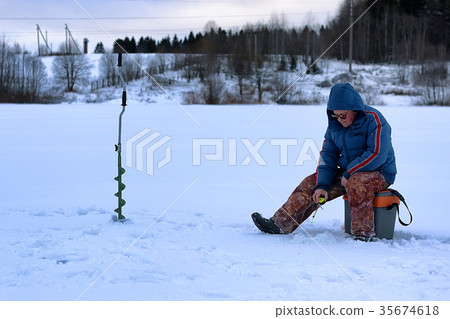 elderly man fishing in the winter on the lake elderly man fishing in the winter on the lake 35674618