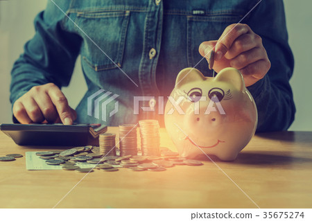 concept saving money with hand putting coins 35675274