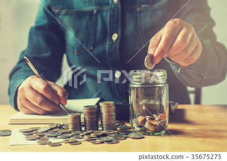 businesswoman saving money with putting coins businesswoman saving money with putting coins 35675275