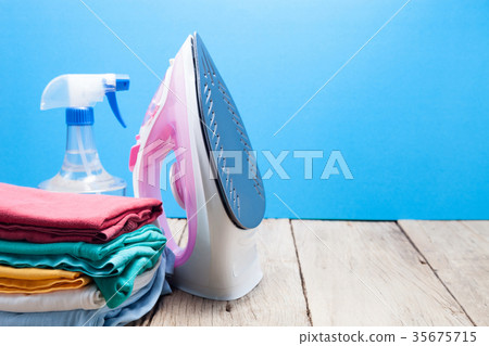 Pile of colorful clothes and irons,spray bottles 35675715
