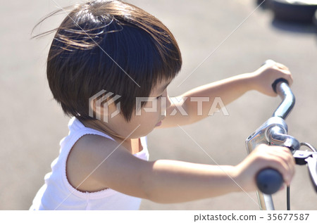 A girl riding a bicycle A girl riding a bicycle 35677587