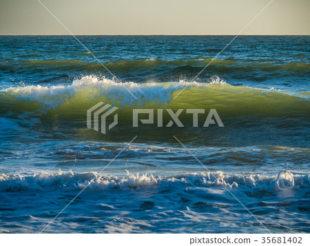 The waves are lighted by the sunset 35681402