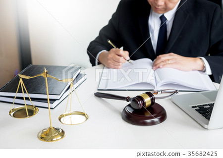 lawyer hand writes the document in court (justice, law) with sou 35682425