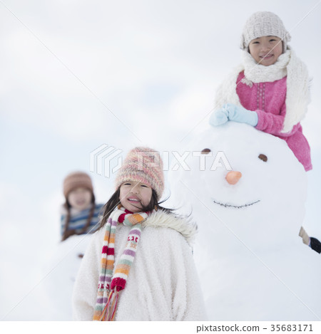 Primary school student smiling around a snowman 35683171
