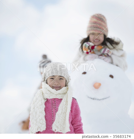 Primary school student smiling around a snowman 35683174