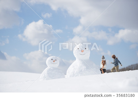 Primary schoolchild playing snow with snowman 35683180