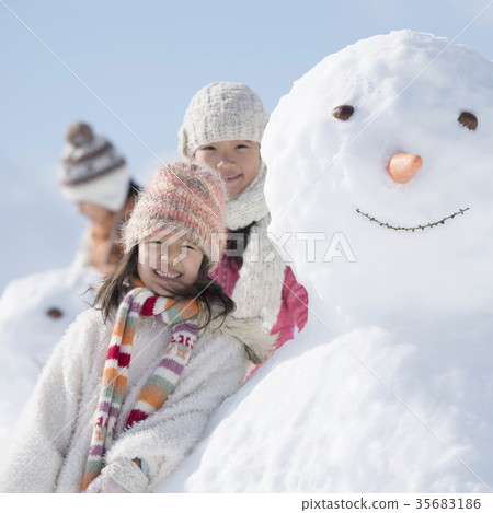 Primary school student smiling around a snowman Primary school student smiling around a snowman 35683186