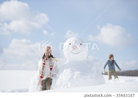微笑在雪人附近的小學學生 35683187