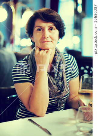 Elderly lonely woman at dinner in restaurant Elderly lonely woman at dinner in restaurant 35686387