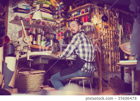 Male worker stitching new belt 35686478