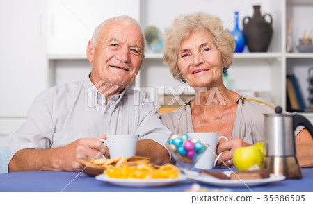 Happy senior couple enjoying conversation over cup of coffee Happy senior couple enjoying conversation over cup of coffee 35686505