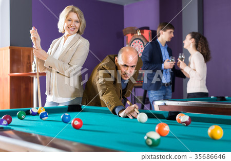 Group of adults playing pool. Group of adults playing pool. 35686646