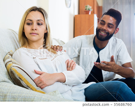 Indoors portrait of mixed couple trying to reconcile after quarrel 35686760