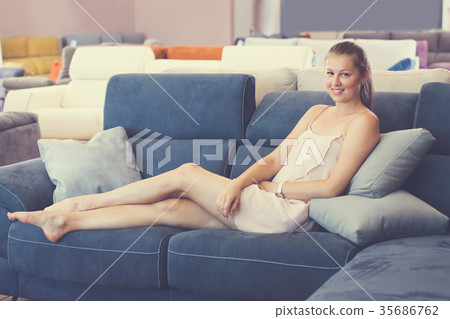 Glad female customer barefoot choosing sofa Glad female customer barefoot choosing sofa 35686762