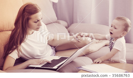 Girl is working on laptop while child naughty Girl is working on laptop while child naughty 35686763