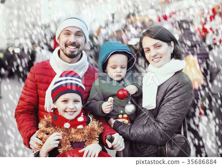 Parents with kids choosing X-mas decorations in market 35686884
