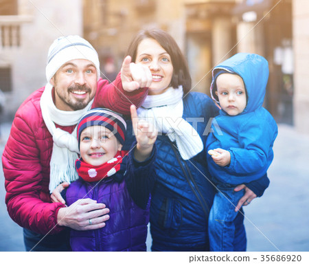 Family of four walking in city and looking showplace 35686920