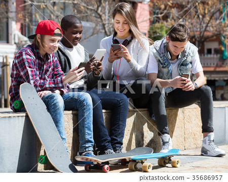 Teenage relaxing with mobile phones Teenage relaxing with mobile phones 35686957