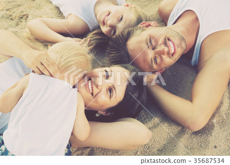 family lying on beach, top view. family lying on beach, top view. 35687534