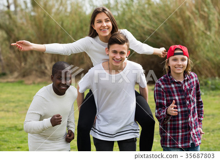 Portrait of ordinary friends running on field Portrait of ordinary friends running on field 35687803