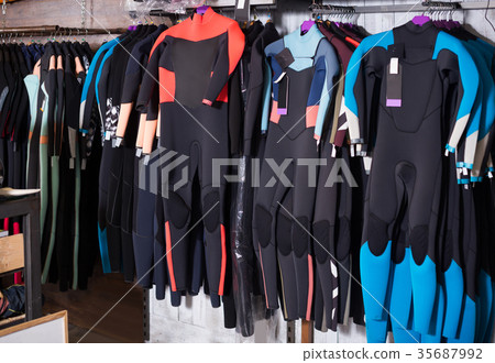 Image of colorful wetsuit hanging in the shop for surfing 35687992