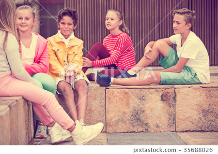 Two boys and three girls are talking about play on walk 35688026