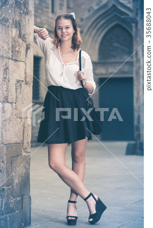 smiling female standing near the stone wall smiling female standing near the stone wall 35688043