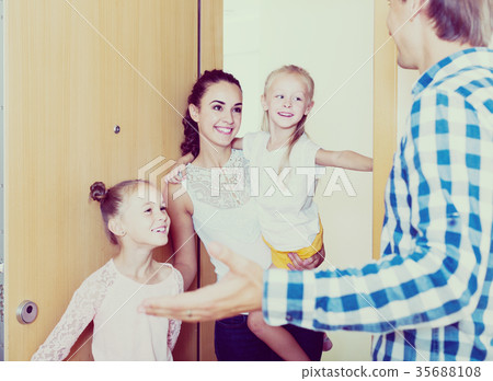 Adults and kids meeting at doorway and greeting one another 35688108