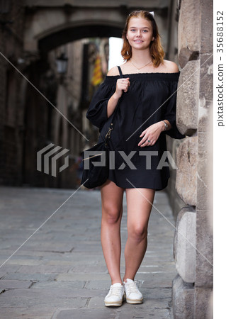 smiling female standing near the stone wall 35688152