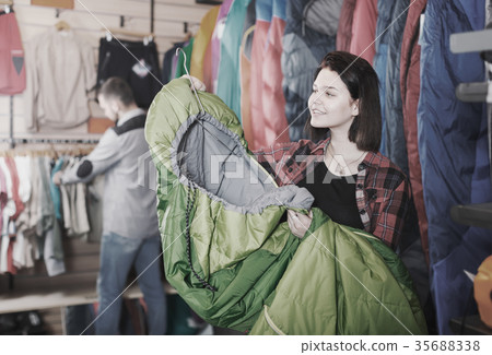 Ordinary female customer examining sleeping bags 35688338