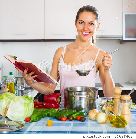 Female cooking with veggies at home. 35688462
