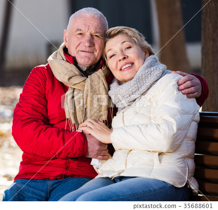 Mature couple sitting in park 35688601