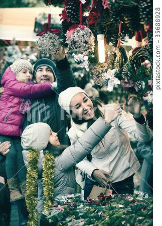 Family standing at coniferous souvenirs counter 35688928