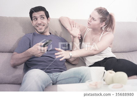 Couple arguing because of TV remote 35688980