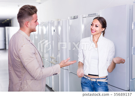 shop assistant helps woman shop assistant helps woman 35689137