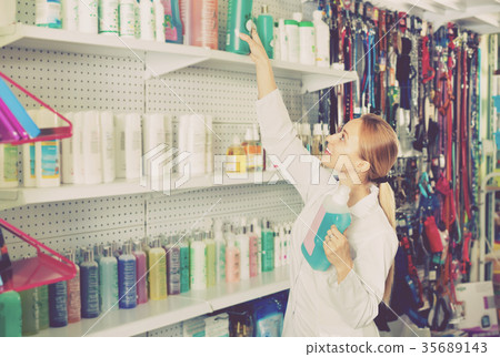 Young woman seller showing types of pet shampoo 35689143